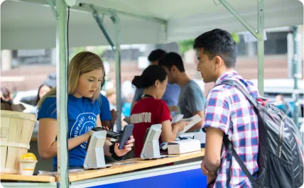 person aiding in a transaction at an outdoor venue