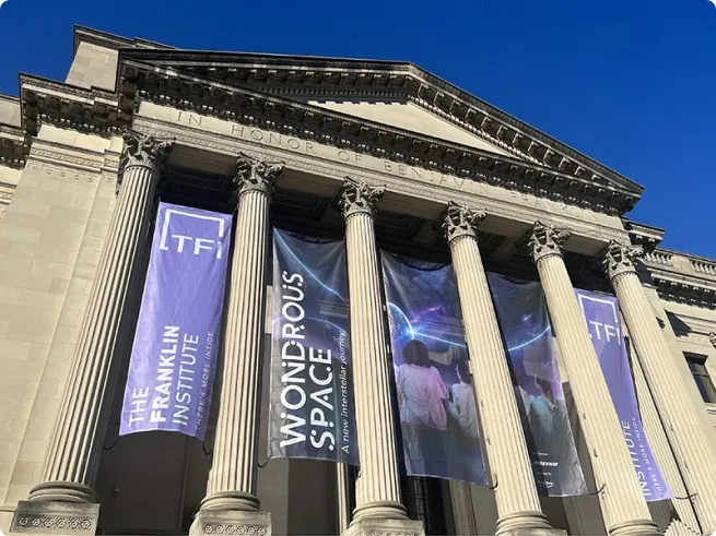 frontside of building with large columns and colorful banners