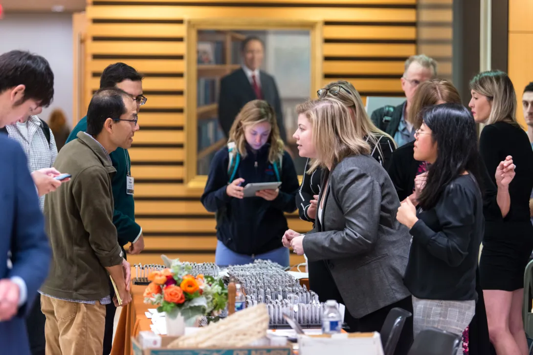 People gathered around a conference registration table with name badges