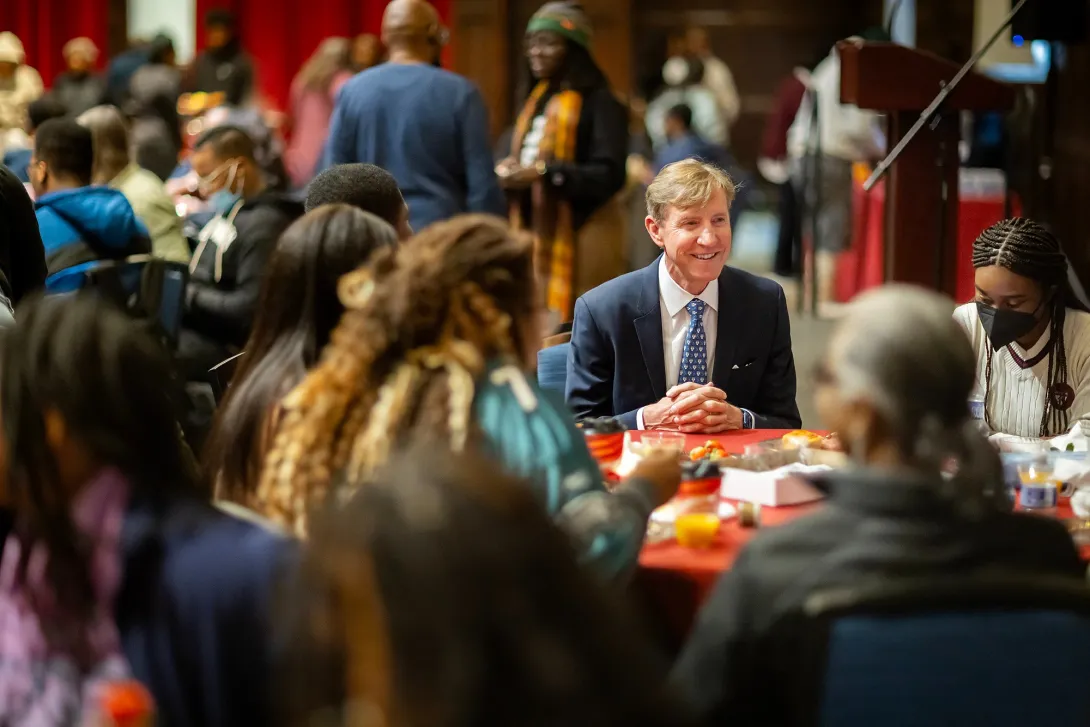 Penn President Larry Jameson seated at a round table with African American students