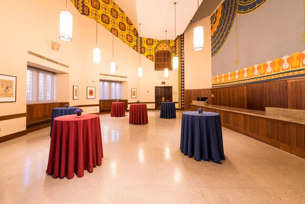 Decorative meeting room with high top tables with red and blue table clothes throughout the space